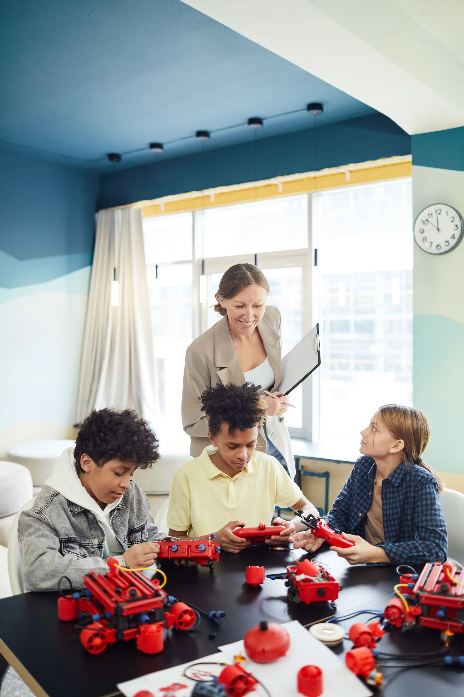 Reference photograph of an educator guiding children through a robotics activity